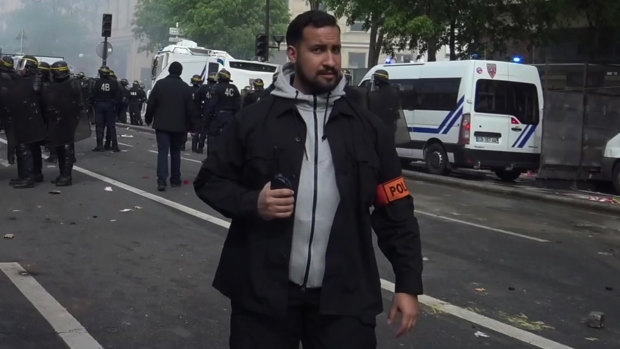 Wearing a police patch, French presidential security chief Alexandre Benalla patrols during clashes with activists on the sidelines of the  traditional May Day rally, in Paris.