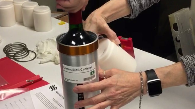 Researchers prepare bottles of French red wine to be flown aboard a Northrop Grumman capsule from Wallops Island, Virginia. 