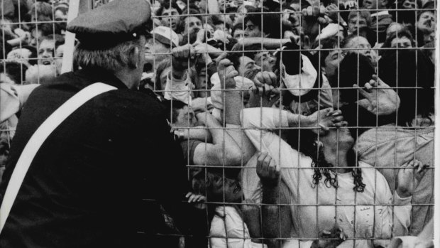 An ambulance worker looks on as Liverpool fans are crushed against a barrier during the Hillsborough disaster.