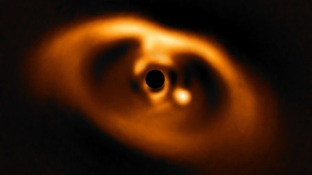 The first clear image of a planet - the bright point to the right of  centre - caught in the very act of formation around the dwarf star PDS 70. 