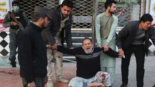 A relative of a victim is helped as he cries after a deadly suicide attack in Kabul on January 27, 2018. 