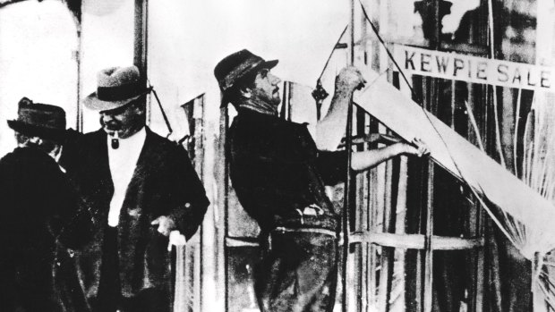 Workmen board up damaged shops in Melbourne during the Victorian Police strike.