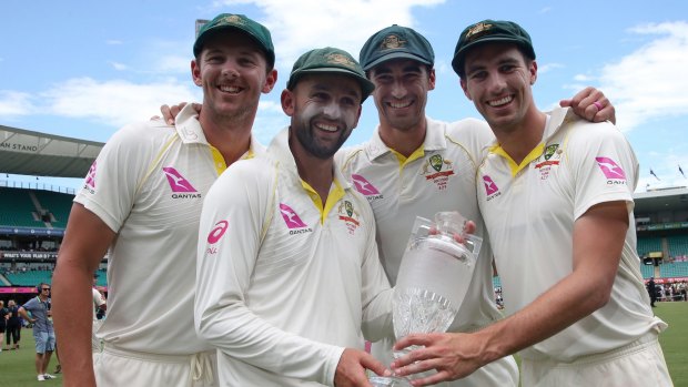 Australian bowlers Josh Hazlewood, left, Nathan Lyon, Mitchell Starc and Pat Cummins hold the Ashes trophy in January.