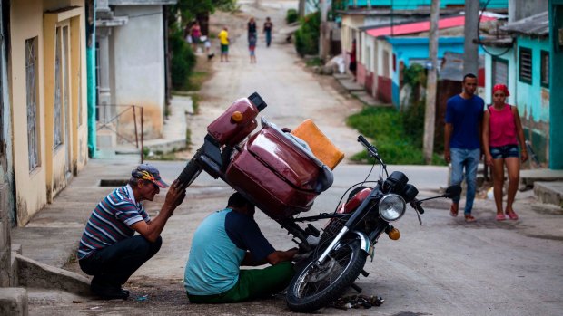 Men repair a motorcycle in the Vigia neighbourhood of Santa Clara, Cuba, the home town of the man who is expected to be Cuba's next president.