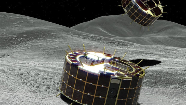 This computer graphic image shows two drum-shaped and solar-powered MINERVA-II 1 rovers on the asteroid.
