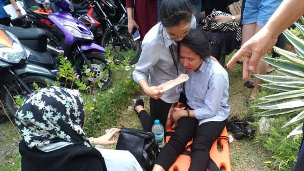 A woman on a stretcher is assisted after a powerful earthquake was felt in Davao City, Philippines, on Tuesday.
