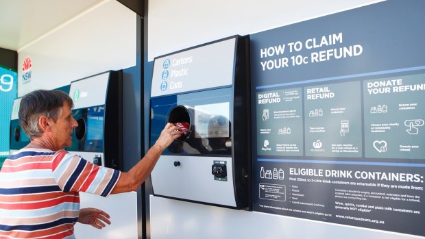 Una Bell loads a can into a Return and Earn recycling machine in Gladesville.