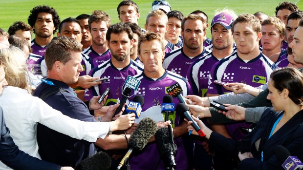 United front: Surrounded by all 22 players, Melbourne Storm coach Craig Bellamy addresses the media after the Storm were penalised for cheating the salary cap in 2010.