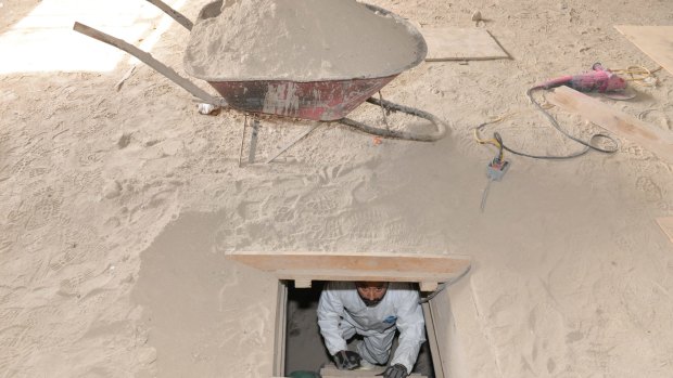 A forensics worker climbs up a ladder to the exit of the tunnel used by Guzman to escape from the Altiplano maximum security prison.