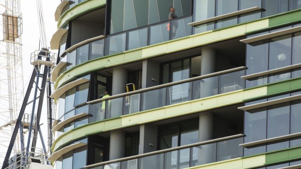 Tradesmen work on Opal Tower in Olympic Park which was evacuated in December.