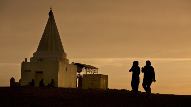 Women visit a Yazidi shrine overlooking at Kankhe Camp for the internally displaced in Dahuk, northern Iraq. 
