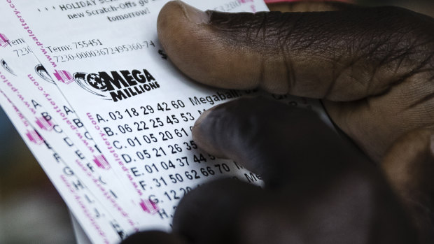 A lottery player looks over his Mega Millions lottery tickets he purchased at a news stand in Philadelphia.