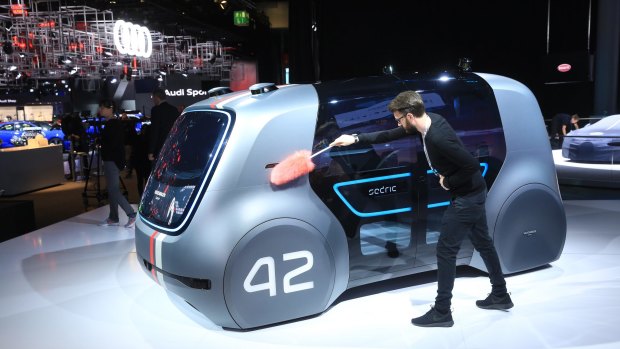 An employee dusts a VW Sedric concept electric autonomous robo-taxi ahead of the IAA Frankfurt Motor Show.