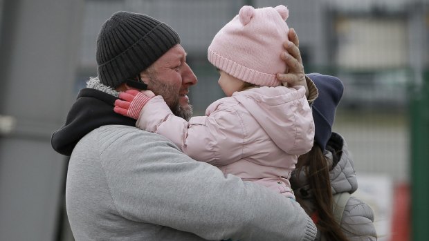 A father hugs his daughter as the family reunite after fleeing Ukraine at the Medyka border crossing. 