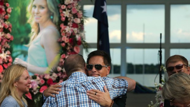 Don Damond hugs a loved one prior to a memorial service for his fiancee, Justine Damond, in August last year.