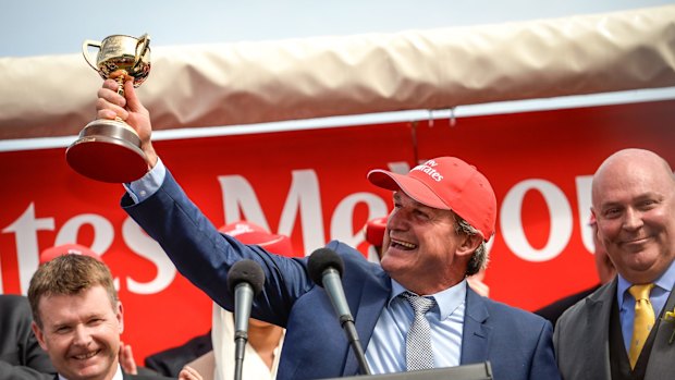 Trainer Darren Weir holds aloft his 2015 Melbourne Cup.