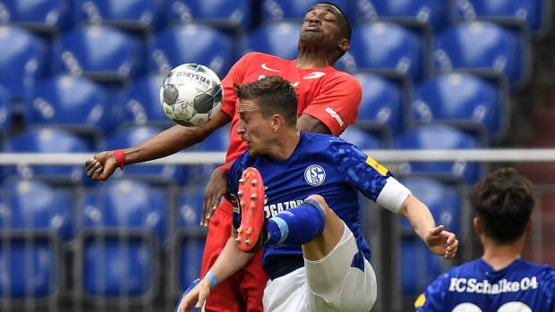 Schalke's Bastian Oczipka (front) competes with Augsburg's Felix Uduokhai during the Miners' 3-0 Bundesliga loss on Sunday.