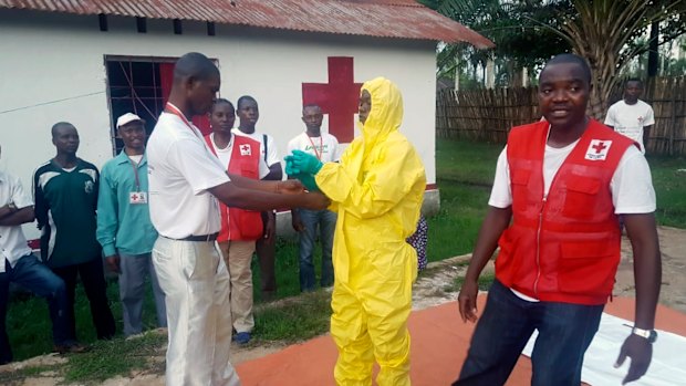 A Red Cross team dons protective clothing before heading out to look for suspected victims of Ebola, in Mbandaka. 