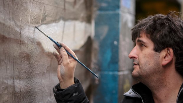 Street artist Adrian Doyle at work in Hosier Lane.