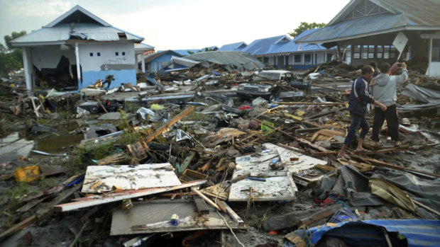 Indonesian men survey the damage following earthquakes and a tsunami in Palu, Central Sulawesi.