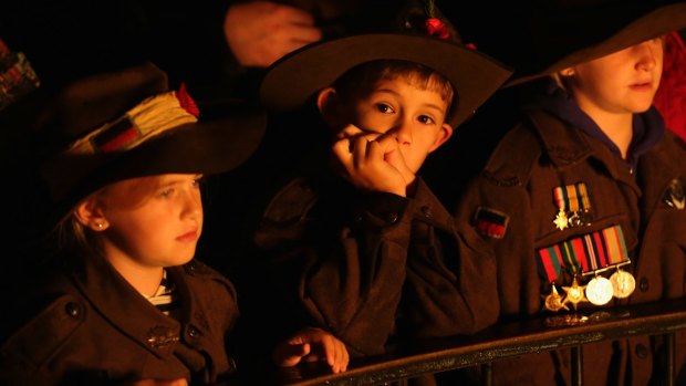Young children look on during the Anzac Day Dawn Service at the Shrine of Remembrance in 2017.