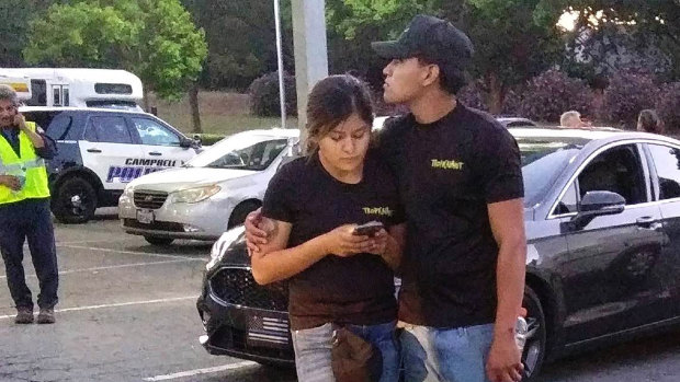 A young couple embrace at a parking lot after a shooting at the Gilroy Garlic Festival in Gilroy, California.