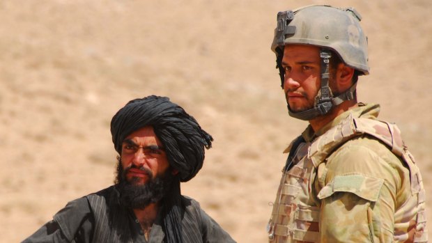 Jesse Bird (right) speaking to Afghan locals while conducting  identity checks in Afghanistan.