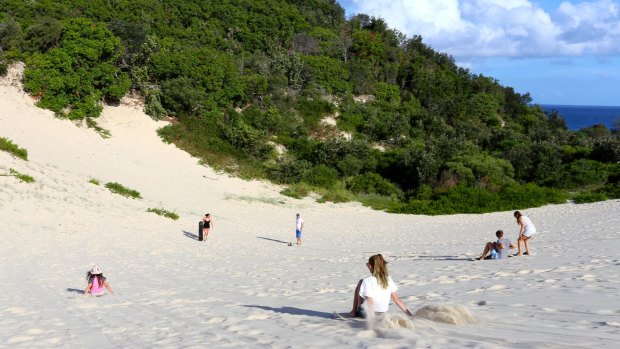 Tourists sandboarding on North Stradbroke Island.