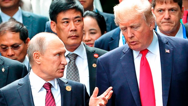 US President Donald Trump, right, and Russia President Vladimir Putin talk during the family photo session at the APEC Summit in Danang last year.