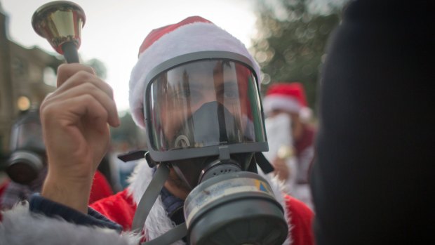 A Palestinian protester, dressed as Santa Claus with a teargas mask during a protest on Saturday.