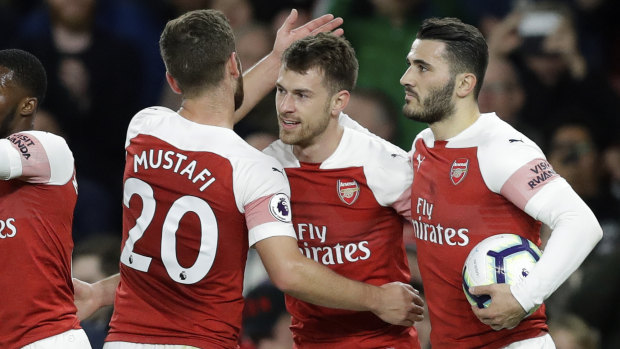 Celebrations: Arsenal teammates swamp Ramsey after he finally opened the scoring for Unai Emery's side.