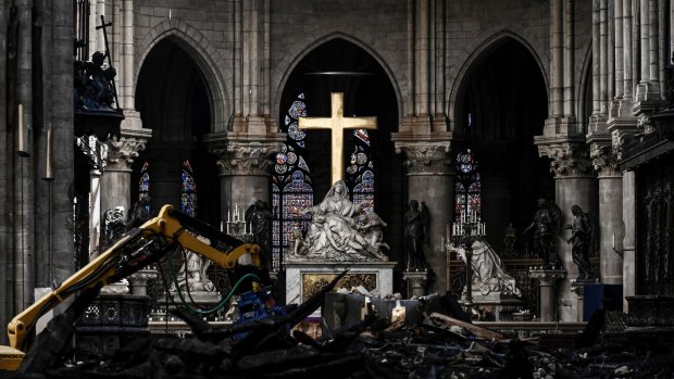 Rubble lies below the Pieta sculpture and a cross inside the Notre Dame de Paris cathedral.