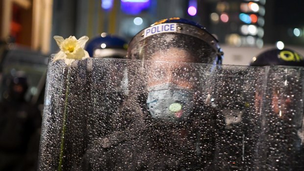 A police officer has a flower placed on his riot shield by a protester in Bristol, England. 
