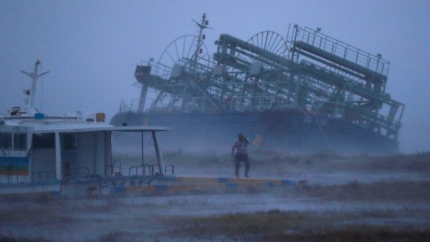 A vessel tilts after running ashore as typhoon Trami approached Yonabaru, southern Japan, on Saturday.
