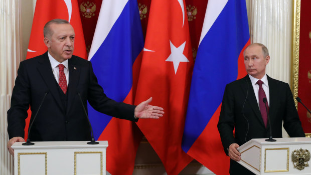 Turkey's President Recep Tayyip Erdogan, left, gestures as Russian President Vladimir Putin listens to him during a joint news conference following their talks in Moscow on Wednesday.