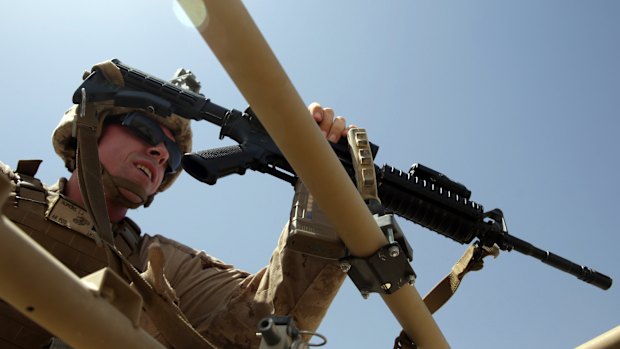 US Marine prepares for a training session for Afghan army commandos in the Shorab military camp in Helmand province, Afghanistan. 