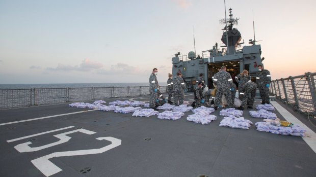 Crew members of HMAS Warramunga lay parcels of seized heroin on the flight deck of the ship during an operation in the Western Indian Ocean, seizing 915kg of heroin valued at more than AUD$274 million in January 2018.