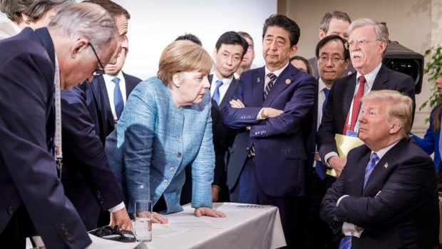 German Chancellor Angela Merkel, centre, speaks with US President Donald Trump during the G7 Leaders Summit.