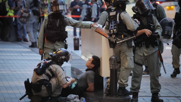 Police detain a protester during a march marking the anniversary of the Hong Kong handover from Britain to China.