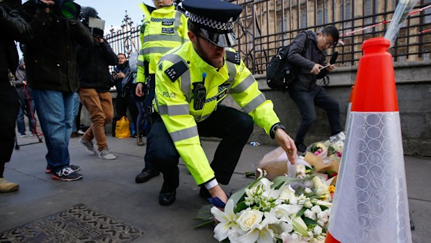 A police officer lays flowers as he pays his respects to victims of a terror attack outside the Houses of Parliament in London last year.