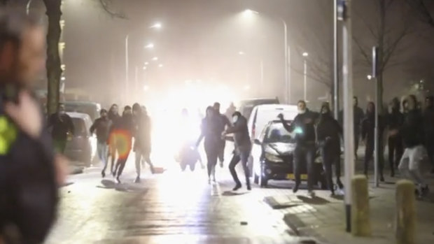 In this grab taken from a video, rioters throw stones at police, in Haarlem, Netherlands. 