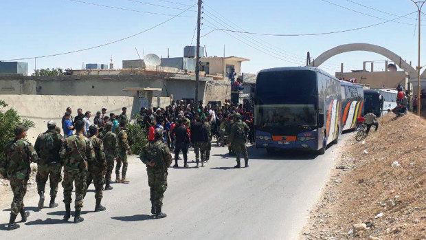 This photo released by the Syrian official news agency SANA, shows Syrian government forces overseeing the evacuation by bus of rebels and their family from the towns of Ruhaiba in the eastern Qalamoun region in the Damascus countryside.