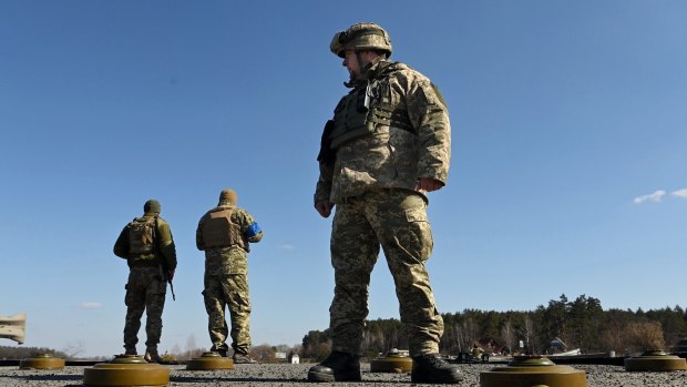 Commander Sulyemnko (right) with the 72nd Brigade standing on a destroyed bridge laid with anti tank mines, east of Kyiv, Ukraine.