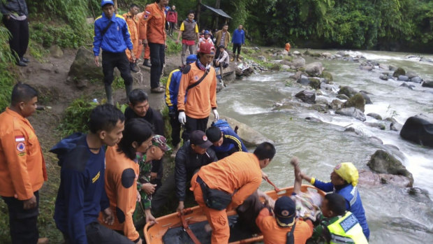 Rescuers remove the body of a victim of a bus accident in Pagaralam, Indonesia, on Tuesday.