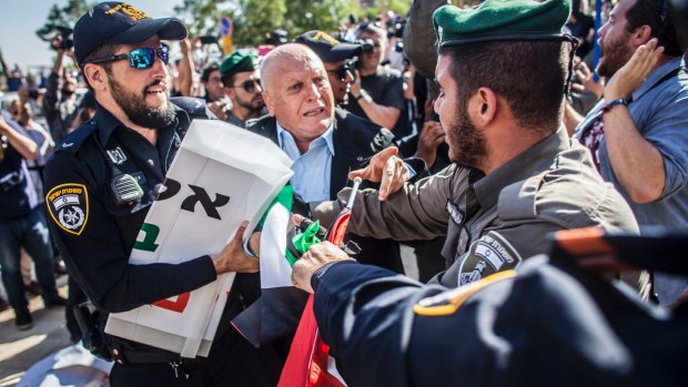 Israeli border police officer pulls a sign from a Palestinian protester outside the new US Embassy in Jerusalem.