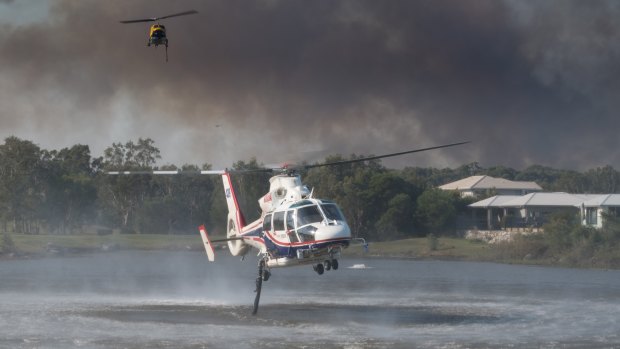 Helicopters take on water to water-bomb the Sunshine Coast bushfires. 
