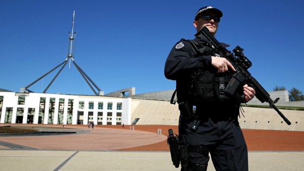 Australian Federal Police officers patrol the front of Parliament House in Canberra. 