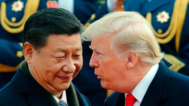 U.S. President Donald Trump, right, chats with Chinese President Xi Jinping during a welcome ceremony at the Great Hall of the People in Beijing. 