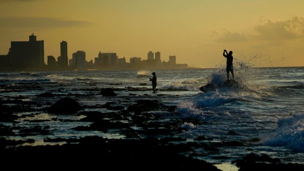 Fishermen prepare their fishing rods on Chivo beach as the sun sets in Havana, Cuba.