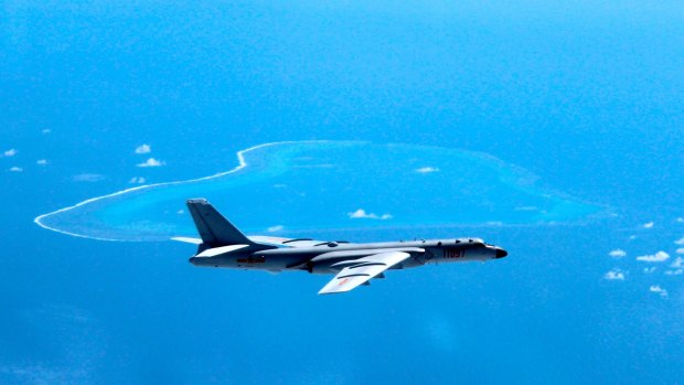 In this undated photo released by Xinhua News Agency, a Chinese H-6K bomber patrols the islands and reefs in the South China Sea. 
